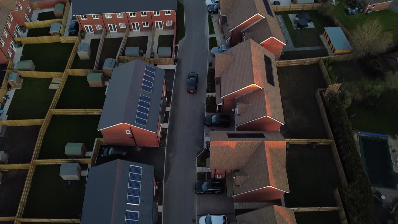 toma de seguimiento de la hora dorada de un automóvil que sale de una casa y luego se desplaza hacia arriba para ver el resto del campo