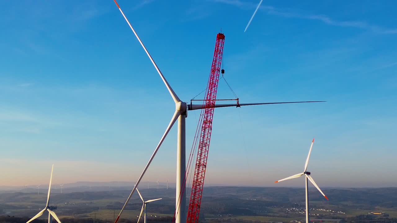 Close aerial view of wind turbine assembly with crane in rural Germany