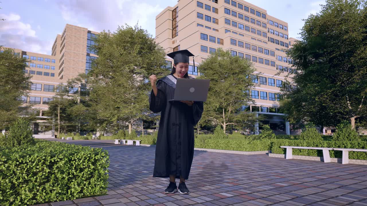 graduado celebrando con una computadora portátil en el campus