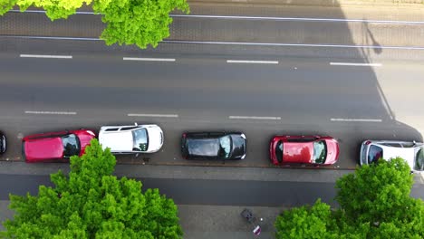 Pedestrians-on-sidewalk,-cars-parked-in-street,-rails-of-an-elevated-train-Aerial-view-flight-bird's-eye-view-drone-footage-in-Berlin-Prenzlauer-Berg-Schönauer-Spring-2022-Cinematic-by-Philipp-Marnitz