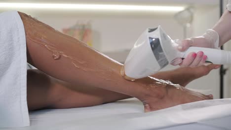 depilación con láser y cosmetología en salones de belleza. cosmetología, spa y concepto de depilación. procedimiento de depilación láser de las piernas femeninas. médico en guantes.