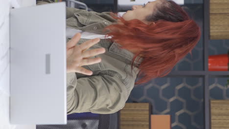 vertical video of business woman looking scared at laptop.