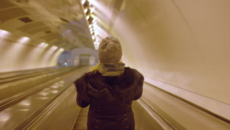 woman on escalator in tunnel