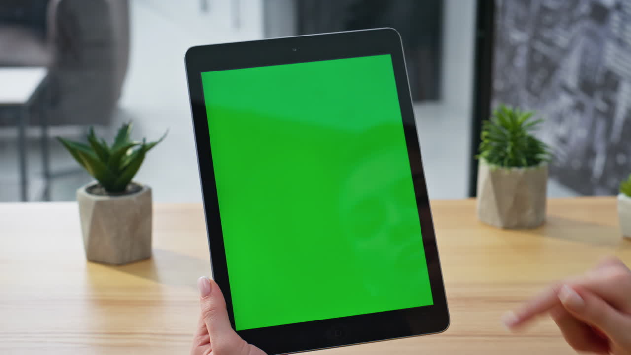 Tablet user scrolling chromakey display surfing internet at home office closeup