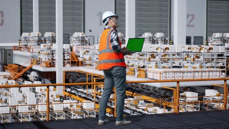 warehouse worker inspecting inventory on laptop