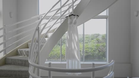 sunlight shines on bride's wedding dress hanging