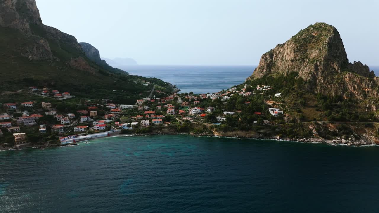 Super slow motion drone footage in 4K of Sant Elia and Capo Zafferano in Sicily Italy showing crystal clear water steep cliffs and colorful coastal homes near Porticello and Bagheria