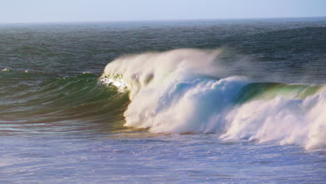 slow motion breaking surf rolling towards coast. powerful foamy waves crashing