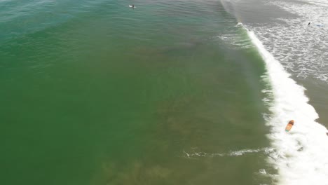 Aerial-shot-of-surfer-catching-a-wave-then-wiping-out