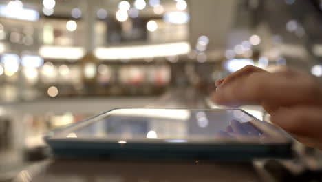 Woman-using-tab-on-handrails-in-shopping-center