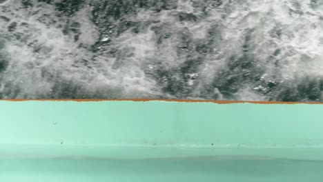 a ferry boat cutting through the waves of the andaman sea, showing the water's motion and ferry's vibrant edge