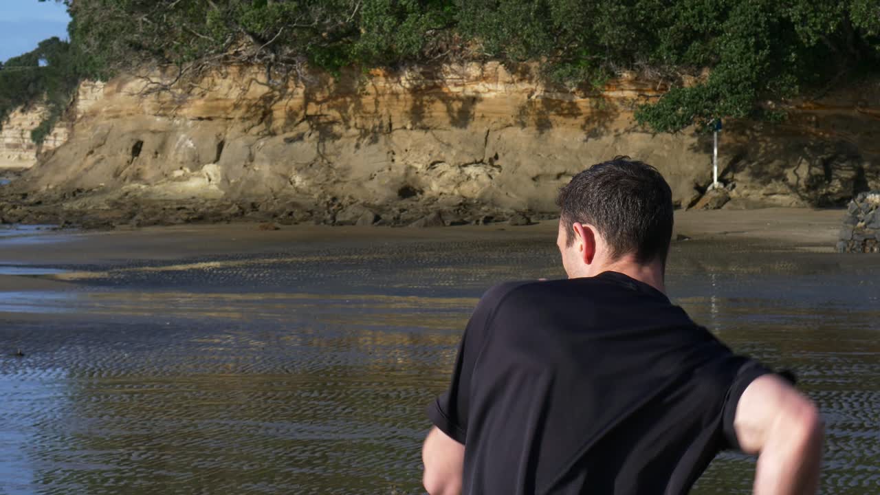 슬로우 모션으로 해변에서 건강을 위해 젊은 남자 에어 복싱을 닫습니다