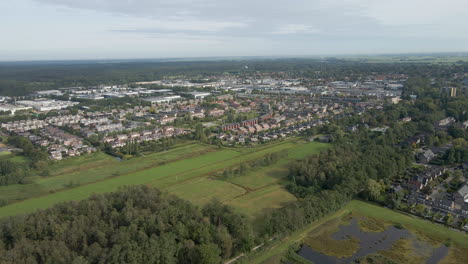 Flying-towards-a-small-town-in-a-beautiful,-green,-rural-area