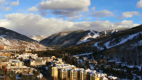 Aerial-Cinematic-Drone-i70-cars-on-highway-at-Vail-Village-Vail-ski-resort-late-afternoon-sunset-of-ski-trails-and-gondola-scenic-mountain-landscape-of-Colorado-up-movement