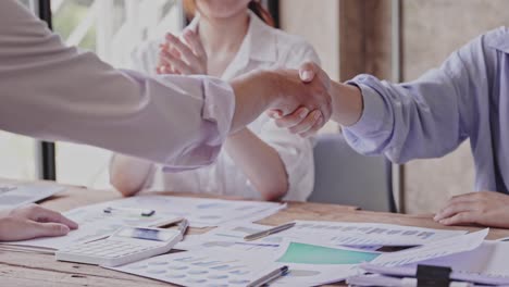 glad to work with you! fashionable young man in smart casual wear holding hands and smiling while working in a creative office.