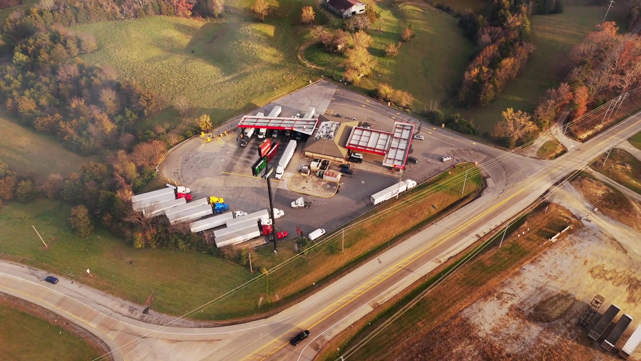 A 4K aerial panning drone shot of a busy truck gas station in Tennessee, capturing trucks pulling in and the industrial operations of the station in vivid detail.