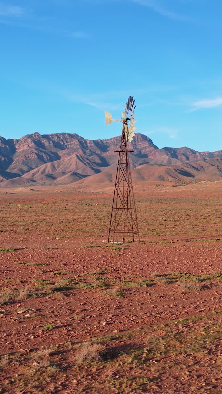 Toma vertical en plano de órbita de un molino de viento con las montañas de Flinders Ranges, Australia Meridional