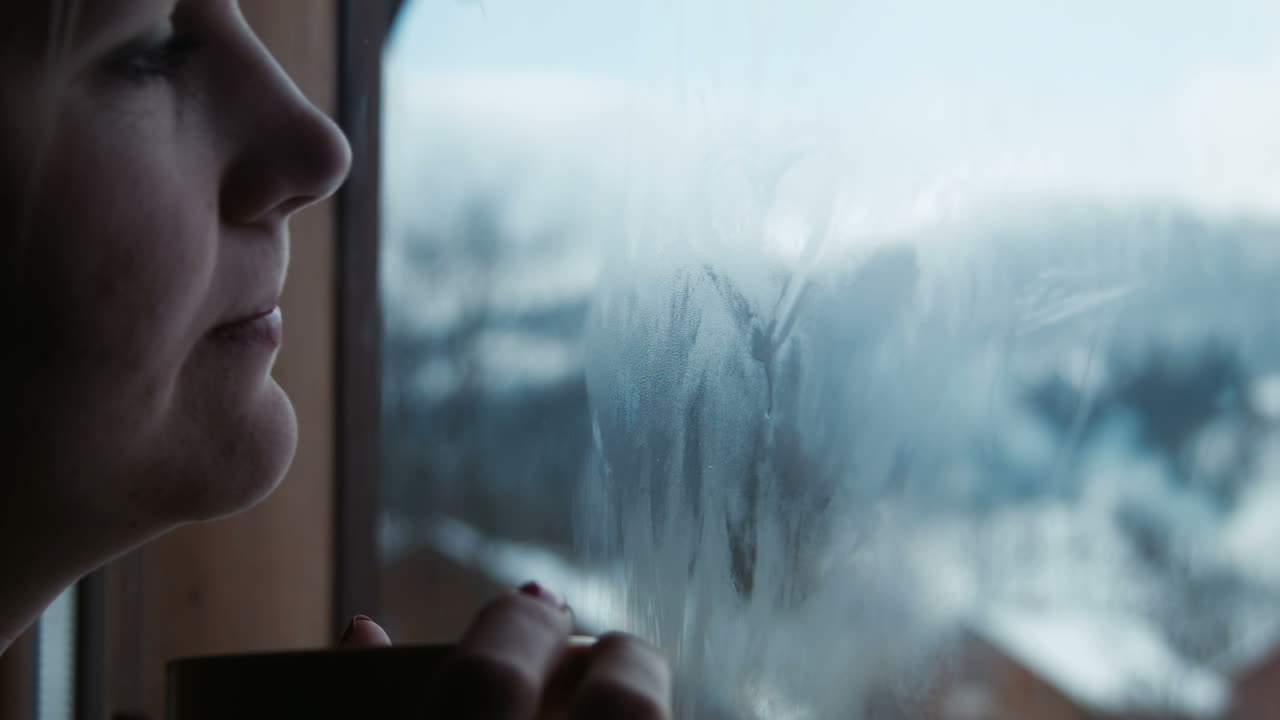 Female Has Tea And Draws Heart On The Window (Stock Footage)