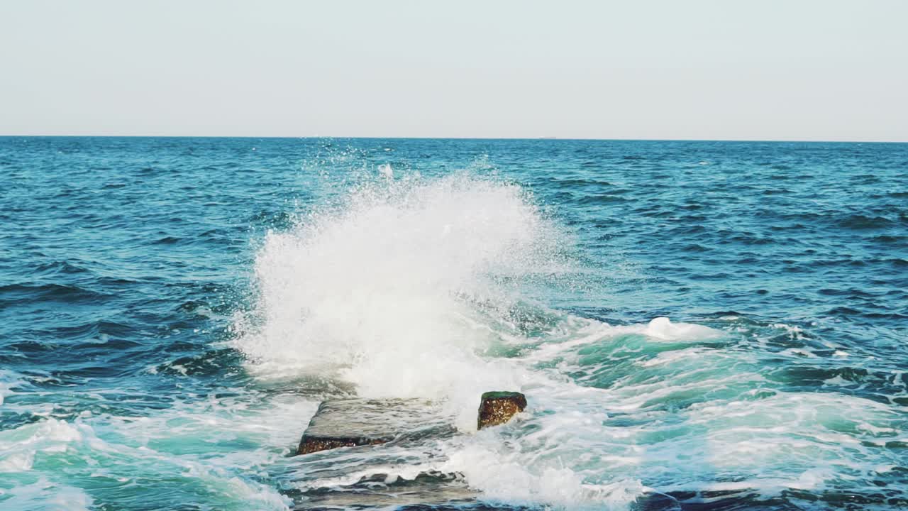 Sea waves are colliding with underwater reefs. Sea spray. Close-up. Water drops. Slow motion
