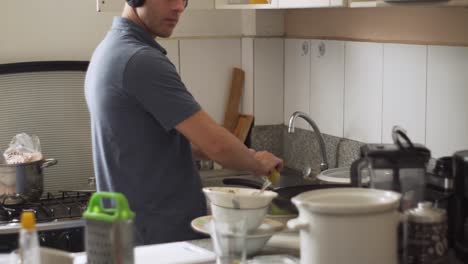 portrait of a man walking into the kitchen sink to wash the dishes