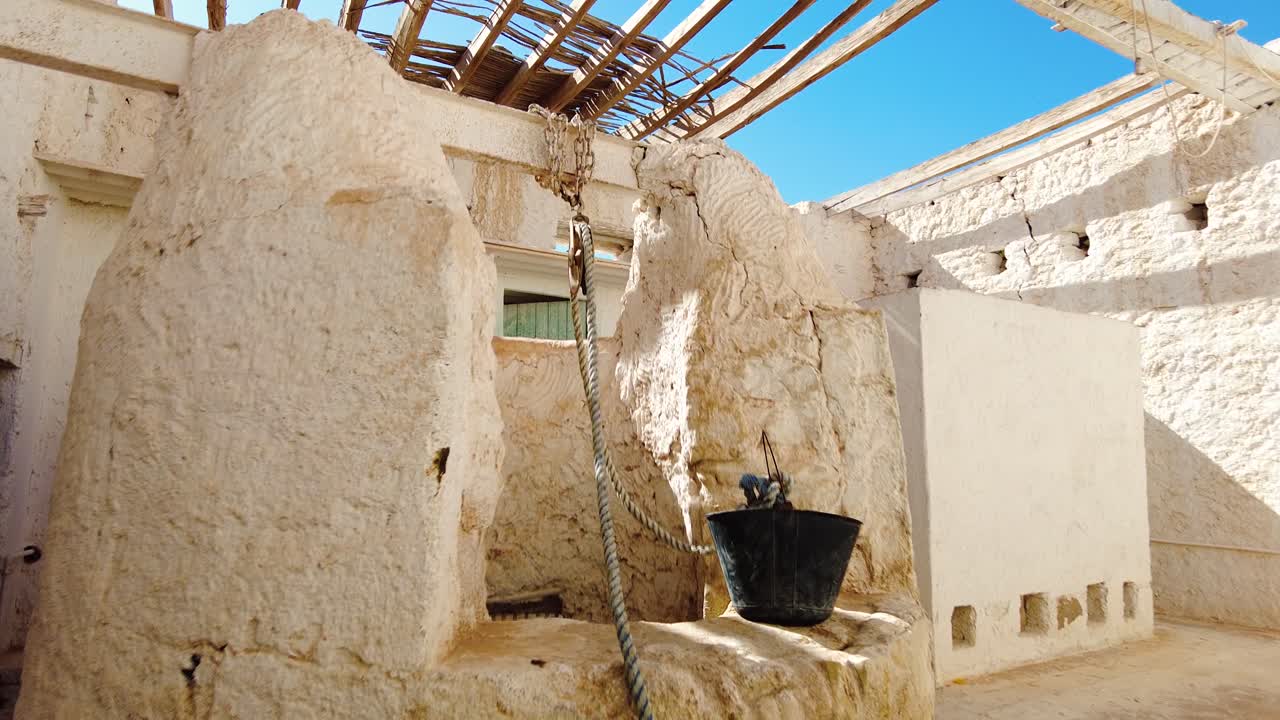 una vecchia casa con un pozzo in mezzo al deserto