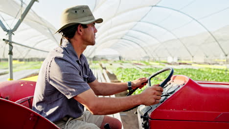 farmer driving a tractor in a greenhouse