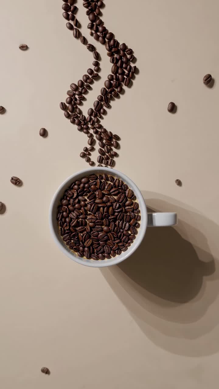 Vista dall'alto di chicchi di caffè che formano vapore sopra una tazza, creando un concetto video fantasioso.
