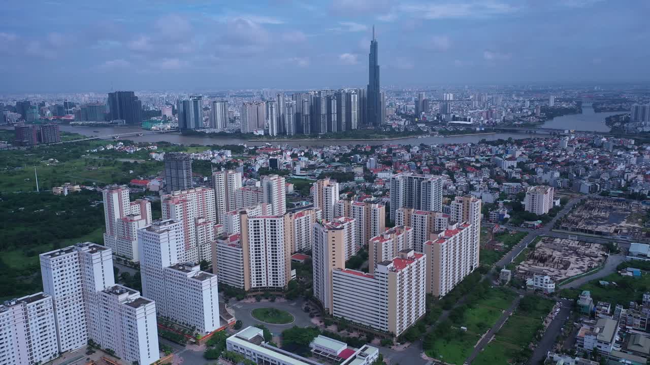vuelo aéreo a un gran desarrollo residencial moderno con el horizonte de la ciudad en el fondo en un día soleado en la ciudad de ho chi minh, vietnam