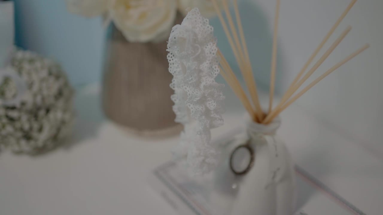 gros plan d'une jarrette de dentelle délicate et d'un diffuseur d'arôme sur une table de mariée