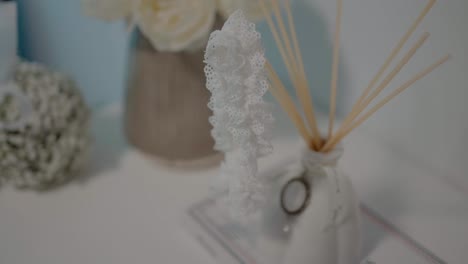 close-up-of-a-delicate-lace-garter-and-aroma-diffuser-on-a-bridal-table