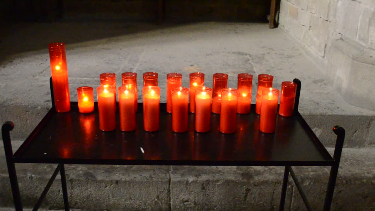 Candele da chiesa in lampadari trasparenti rossi e gialli