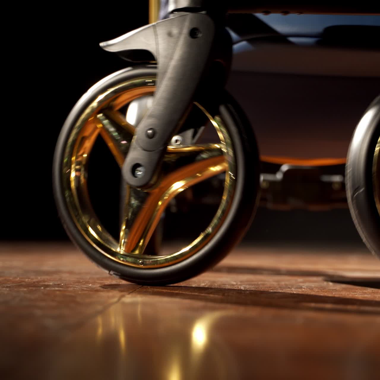 Lower part of dark blue baby stroller with golden elements. Modern perambulator on the smooth floor in the dark room