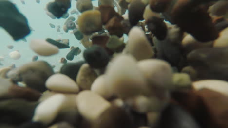 the sea surf fires pebbles in different directions the video was shot under the water