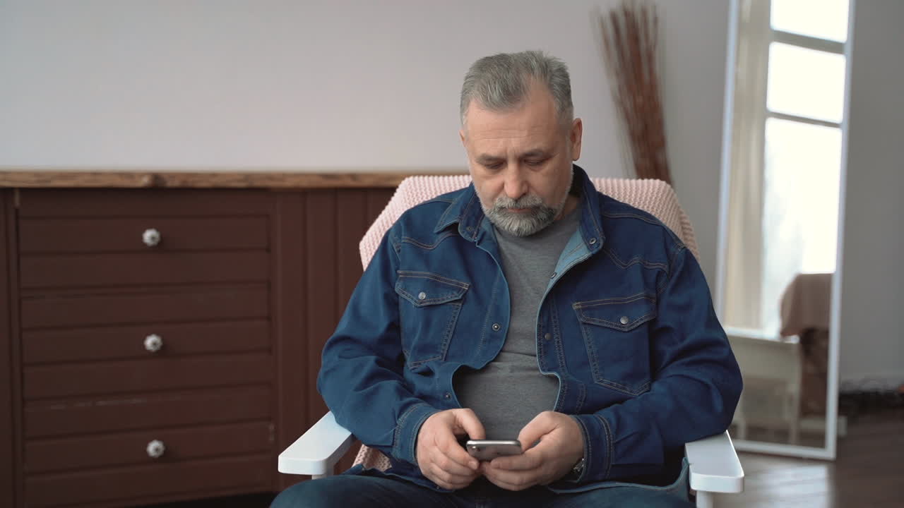 Стоковое видео категории «Бесплатно» — Зрелый мужчина с телефоном, общающийся и пишущий смс