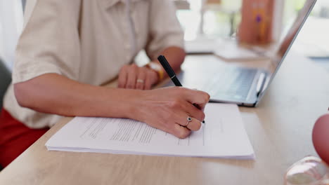 mujer firmando documentos en casa