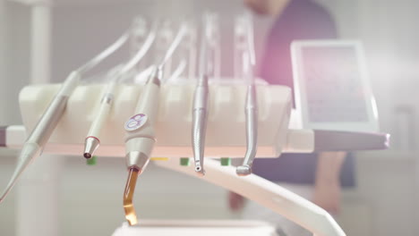 closeup view of sterile dental tools in clinic with dentist walking in back