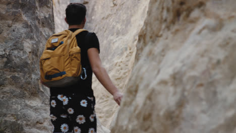 man hiking through rocky canyon