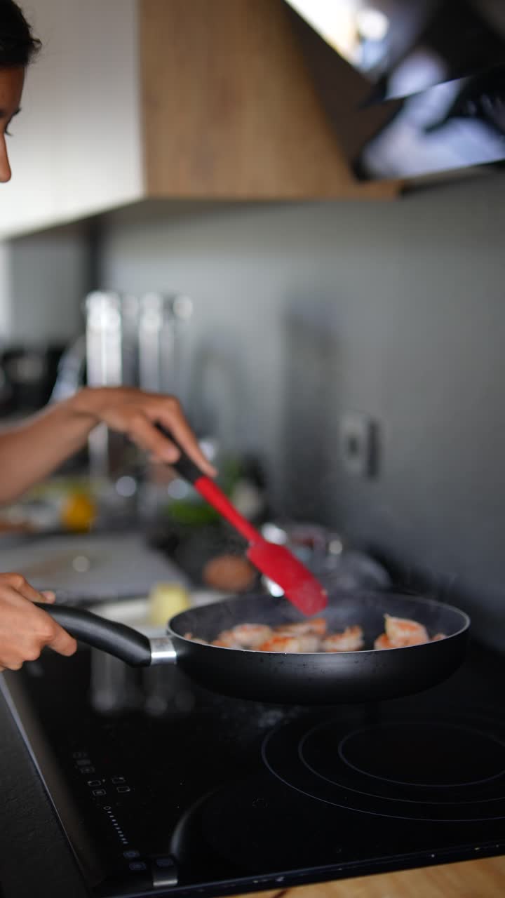 mujer cocinando camarones en una sartén