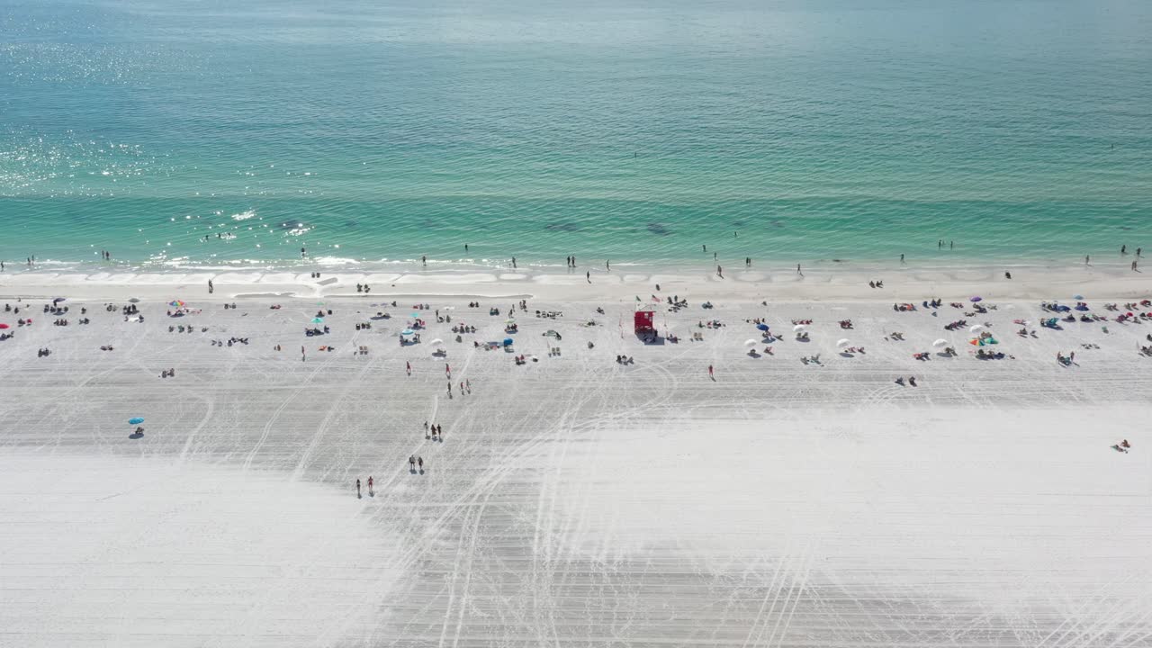 넓은 시에스타 키 해변의 하얀 모래 위에서 놀고 있는 사람들, 해변은 손질되어 있고 바닷물은 청록색입니다