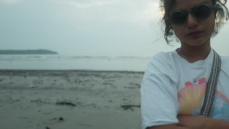 Niña-India-Enojada-Con-Los-Brazos-Cruzados-En-La-Playa-Con-Gafas-De-Sol