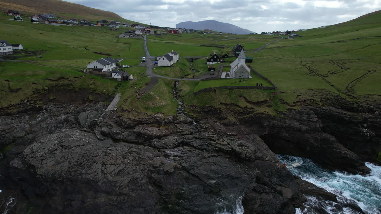 Vi&eth;arei&eth;i church, Faroe Islands: aerial view of the church from a distance and over the sea