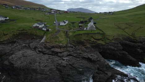 Viðareiði-church,-Faroe-Islands:-aerial-view-of-the-church-from-a-distance-and-over-the-sea