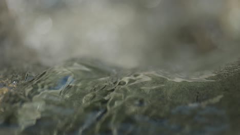 slowmo macro of river running over rocks