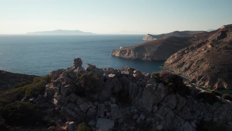 Un-Dron-Se-Eleva-Sobre-Un-Mojón-En-La-Cumbre-Para-Revelar-La-Impresionante-Y-Vasta-Extensión-Del-Océano-Desde-La-Isla-De-Syros,-Grecia