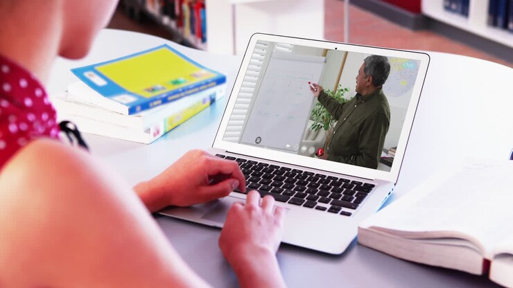 Caucasian female student using laptop on video call with male teacher