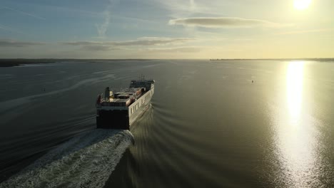 cargo ship sailing at sunrise on calm waters on carlingford lough near dundalk, county louth, ireland, aerial view