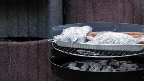 cooking on the big round bbq grill outdoors - panning shot