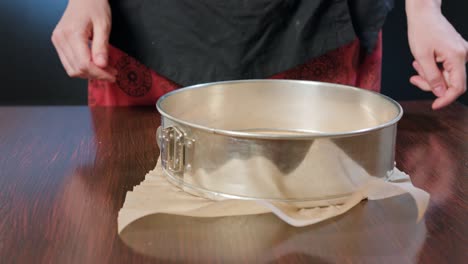 cook preparing a baking pan and baking paper