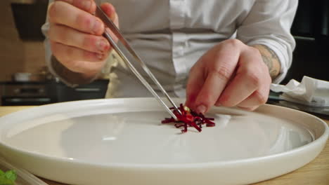 chef plating beetroot with tweezers