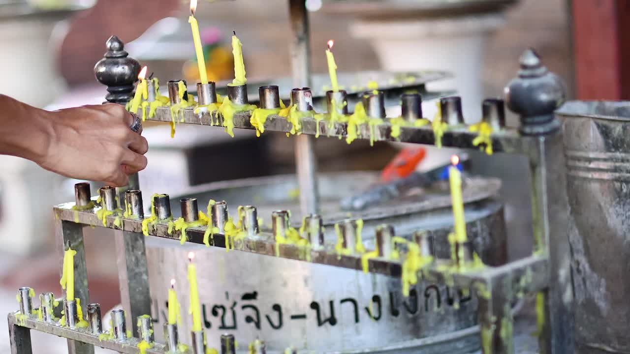 una persona enciende una vela en un santuario